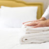 hotel staff setting up pillow on bed